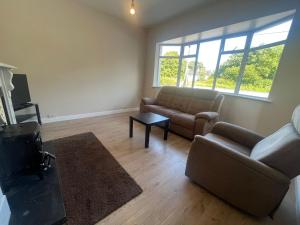 a living room with a couch and a table at Yeats Lodge Self catering Apartment and Bar in Galway