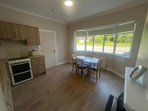 a kitchen and dining room with a table and a window at Yeats Lodge Self catering Apartment and Bar in Galway