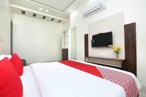um quarto com uma cama grande e uma televisão na parede em LUCKY HOTEL AND RESTAURANT em Kurukshetra