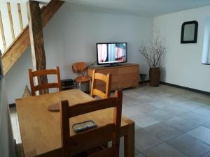 een woonkamer met een tafel en een televisie bij Gîte indépendant neuf, idéal vacances nature au calme, proche rivières, N147 & Civaux in Mazerolles