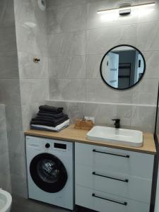 a bathroom with a washing machine and a mirror at STARA CEGIELNIA, Faktura VAT, bezkontaktowe zameldowanie in Poznań