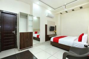 um quarto de hotel com duas camas e uma televisão em LUCKY HOTEL AND RESTAURANT em Kurukshetra