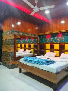 two beds in a room with a wall of wood at Spring Resort & lodging in Mumbai