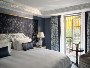 um quarto com uma cama grande e uma janela em The Dorchester - Dorchester Collection em Londres