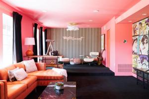 a living room with orange furniture and pink walls at The Palmcroft in Scottsdale