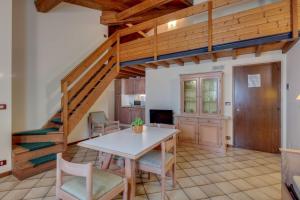 a dining room with a table and chairs and a staircase at Residence La Filanda in Costermano