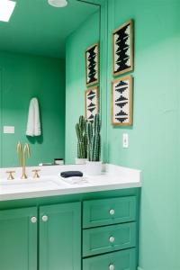 a bathroom with a sink and a green wall at The Palmcroft in Scottsdale