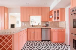 a kitchen with orange cabinets and a black and white tile floor at The Palmcroft in Scottsdale