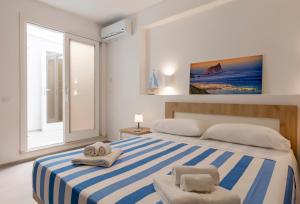 um quarto com uma cama listrada azul e branca com 2 toalhas em Tenuta Pezzeselle - Casa Vacanze em Marettimo