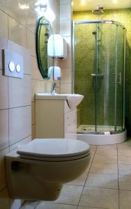 y baño con aseo, lavabo y ducha. en Lawendowa Galeria MINI, en Brożec