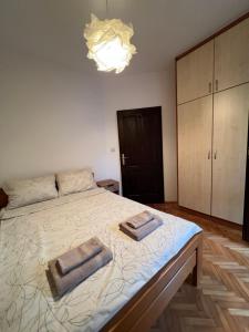 a bedroom with a large bed with two towels on it at City life apartman in Herceg-Novi