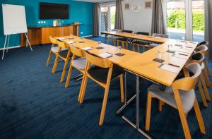 uma sala de conferências com mesas e cadeiras e um quadro branco em Holiday Inn Express Peterborough, an IHG Hotel em Peterborough