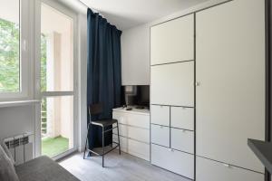 a bedroom with white cabinets and a desk at Wola Comfort Studio #1 in Warsaw