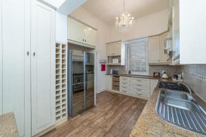 una cocina con armarios blancos y fregadero en 60 on Montagu, en Mossel Bay
