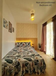 - une chambre avec un lit et une couette dans l'établissement Muji-inspired Home, 2-BR Bungalow Home Trece Martires, à Trece Martires