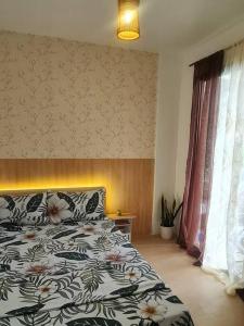 - une chambre avec un lit et une couette à fleurs dans l'établissement Muji-inspired Home, 2-BR Bungalow Home Trece Martires, à Trece Martires