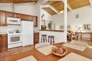 een keuken met witte apparatuur en een tafel in een kamer bij 2331-Ashwood Pines chalet in Big Bear Lake
