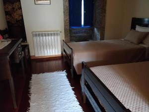 ein Schlafzimmer mit zwei Betten und einem weißen Teppich in der Unterkunft Quinta de São Simão Turismo e Eventos in Vieira do Minho