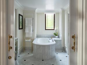 un bagno bianco con una grande vasca e una finestra di The Dorchester - Dorchester Collection a Londra