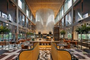 a restaurant with tables and chairs and large windows at Pan Pacific Orchard in Singapore