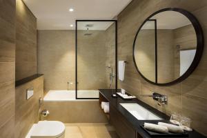 a bathroom with a tub and a sink and a mirror at SILVER FOX HOMES in Dubai