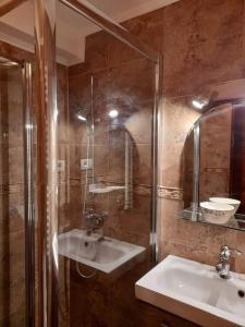 a bathroom with a sink and a shower and a mirror at Adrys Boutique Villa in Constanţa