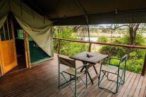 a wooden deck with a table and chairs on a tent at Taranga Safari Lodge in Rundu