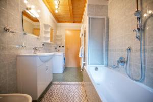 a bathroom with a tub and a sink and a shower at Apartments Culac in Santa Cristina Gherdëina