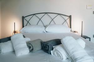 a white bed with pillows and towels on it at Rio Deluxe Villa in Áyios Yeóryios