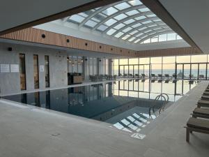 a large swimming pool in a building with a glass ceiling at Sunshine Apartments Batumi Lux in Batumi