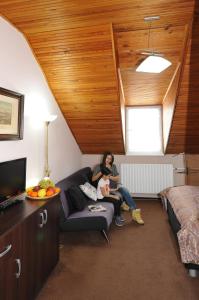 a woman sitting on a couch in a room at Hotel Wilhelm in Prague