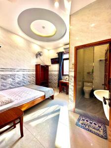 a bedroom with a bed and a bathroom with a sink at Khách sạn Vĩnh Chương in Soc Trang