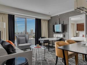 a hotel room with a bed and a living room at Swissotel Sydney in Sydney