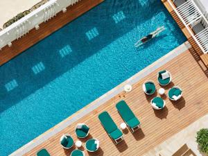 an overhead view of a swimming pool with chaises and chairs at Swissotel Sydney in Sydney