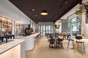 a restaurant with a bar and tables and chairs at Hotel TOTTO Wollongong in Wollongong