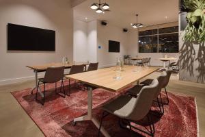 una sala de conferencias con una gran mesa de madera y sillas en Hotel TOTTO Wollongong en Wollongong