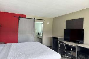 um quarto com uma cama e uma televisão de ecrã plano em Ramada by Wyndham Cocoa em Cocoa