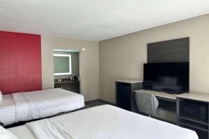 a hotel room with two beds and a flat screen tv at Ramada by Wyndham Cocoa in Cocoa