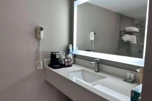 a bathroom with a sink and a mirror at Ramada by Wyndham Cocoa in Cocoa