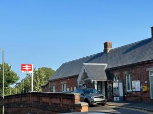 a car parked in front of a brick building at Lovely apartment near Gatwick airport in Reigate