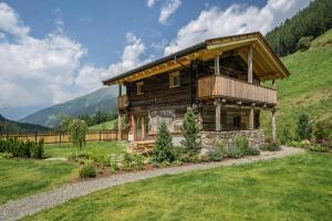 a log cabin on a hill with a green field at Chalet zu Wosser in San Leonardo in Passiria