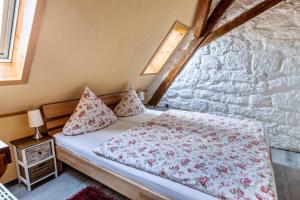 a bedroom with a bed and a stone wall at La Rose in Tengen