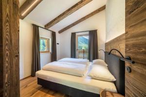 1 dormitorio con 2 camas y ventana en Chalet zu Wosser, en San Leonardo in Passiria