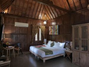 a bedroom with a bed in a wooden room at Amata Borobudur Resort in Borobudur +50 photos