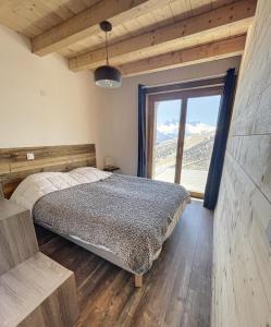 a bedroom with a bed and a large window at Chalet L'Albaron in La Toussuire +12 photos