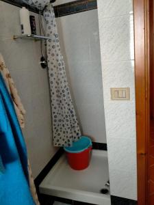uma casa de banho com um chuveiro e um balde em Casa Rosa em Cirò