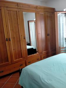 um quarto com armários de madeira e um espelho em Casa Rosa em Cirò