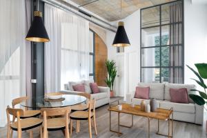 sala de estar con mesa y sofá en Suites Maestranza - Herrería by Magno Apartments, en Sevilla