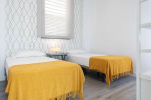 Ein Bett oder Betten in einem Zimmer der Unterkunft Suites Maestranza - Herrería by Magno Apartments