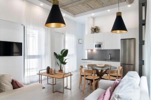 ein Wohnzimmer mit einer Couch und einem Tisch in der Unterkunft Suites Maestranza - Herrería by Magno Apartments in Sevilla